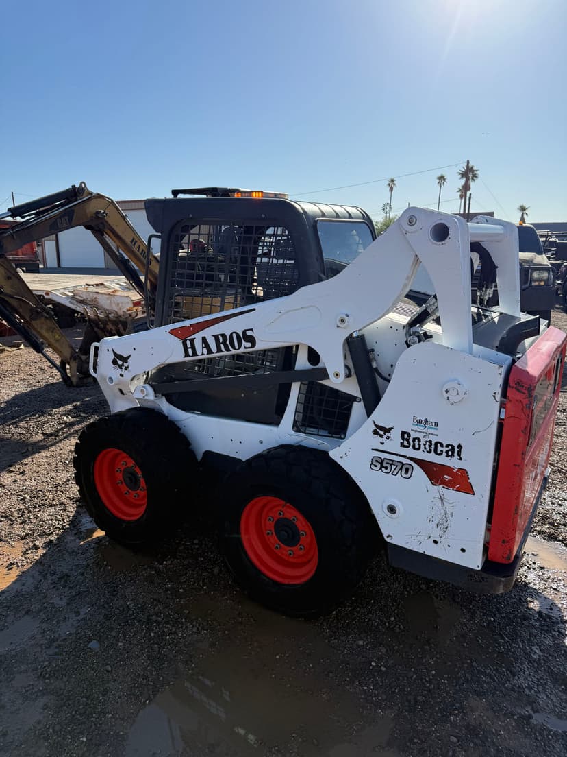 Bobcat 8570 skid steer loader with customized HAROS branding at construction site.